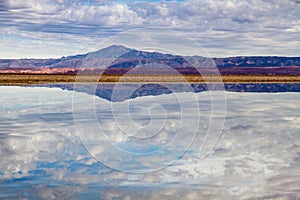 Salt lagoon in the Salar de AtacamaÂ landscape view in the Atacama Desert in Chile, with mountains and volcano reflections